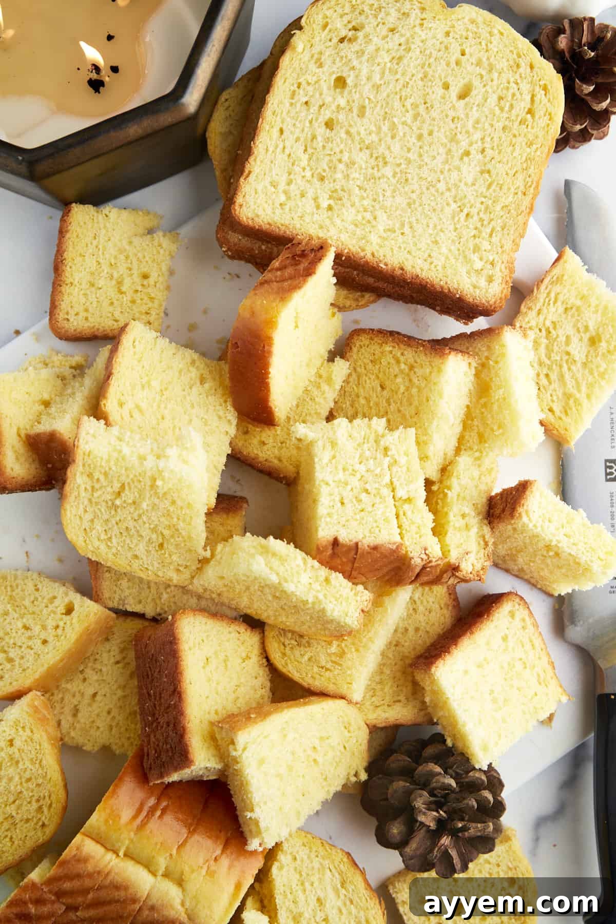 Cubing a loaf of brioche bread into even pieces for the casserole.
