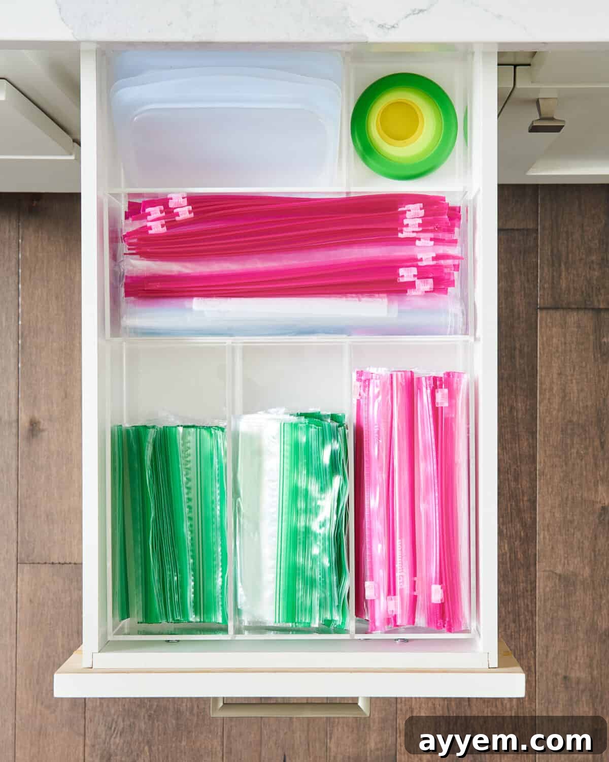 Various kitchen bags meticulously arranged inside a drawer using dedicated organizers, showcasing a pristine and functional storage system.