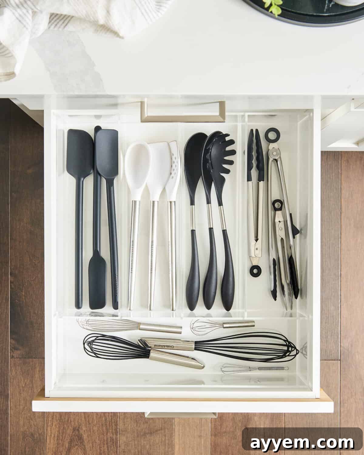 A well-organized open kitchen drawer with various kitchen tools and gadgets, emphasizing effective kitchen storage solutions.