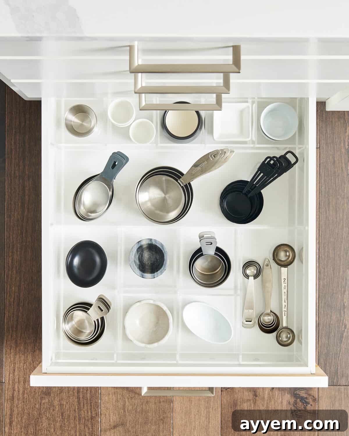 Neatly organized measuring cups and spoons in a drawer, showcasing ideal kitchen gadget organizers for small items.