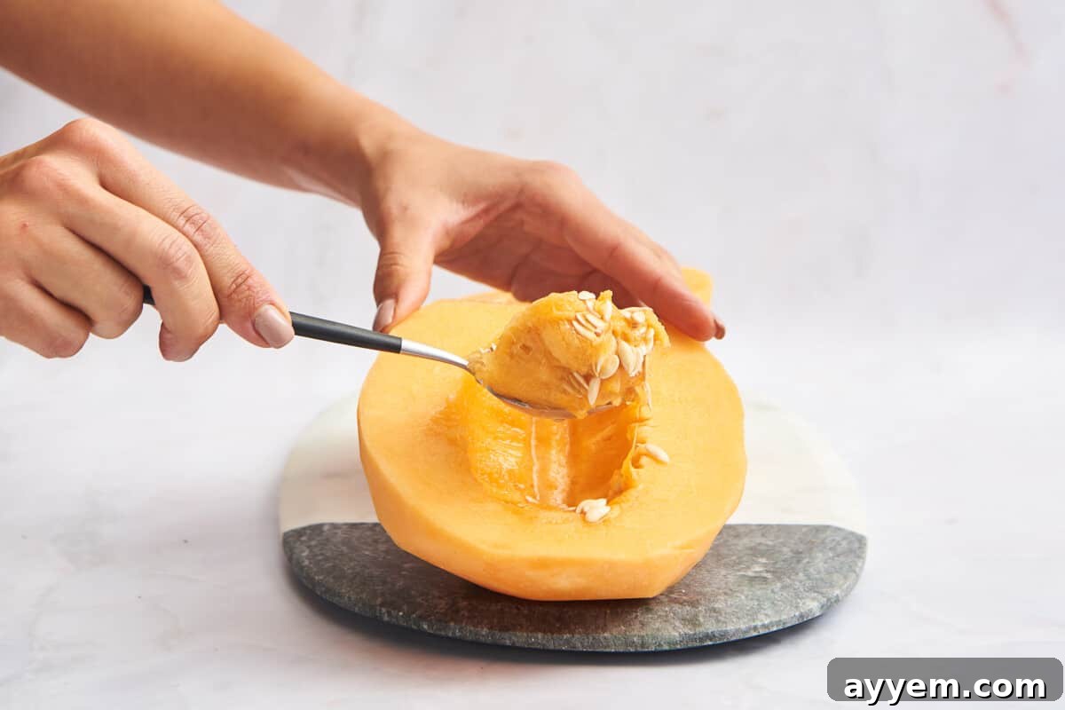 The membrane being removed from a cantaloupe half, showing a clean cavity.