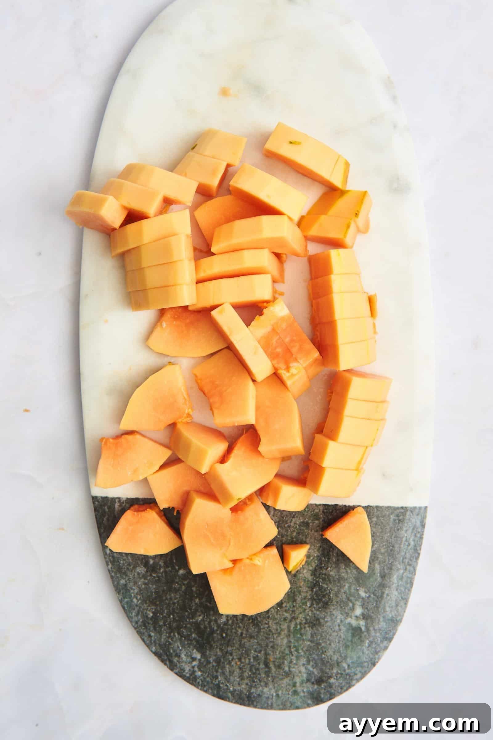 Pieces of papaya on a cutting board.