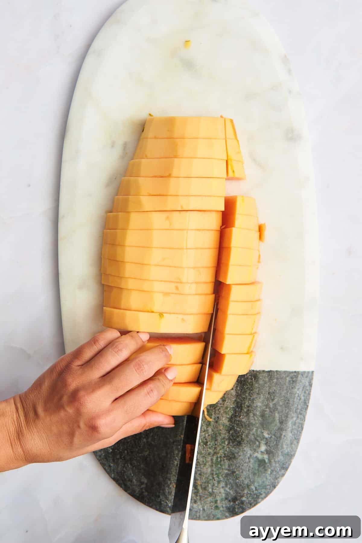 Papaya strips being cut into cubes.