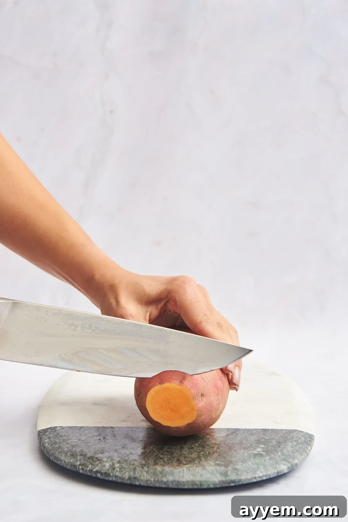 The end of a sweet potato being trimmed before cutting.
