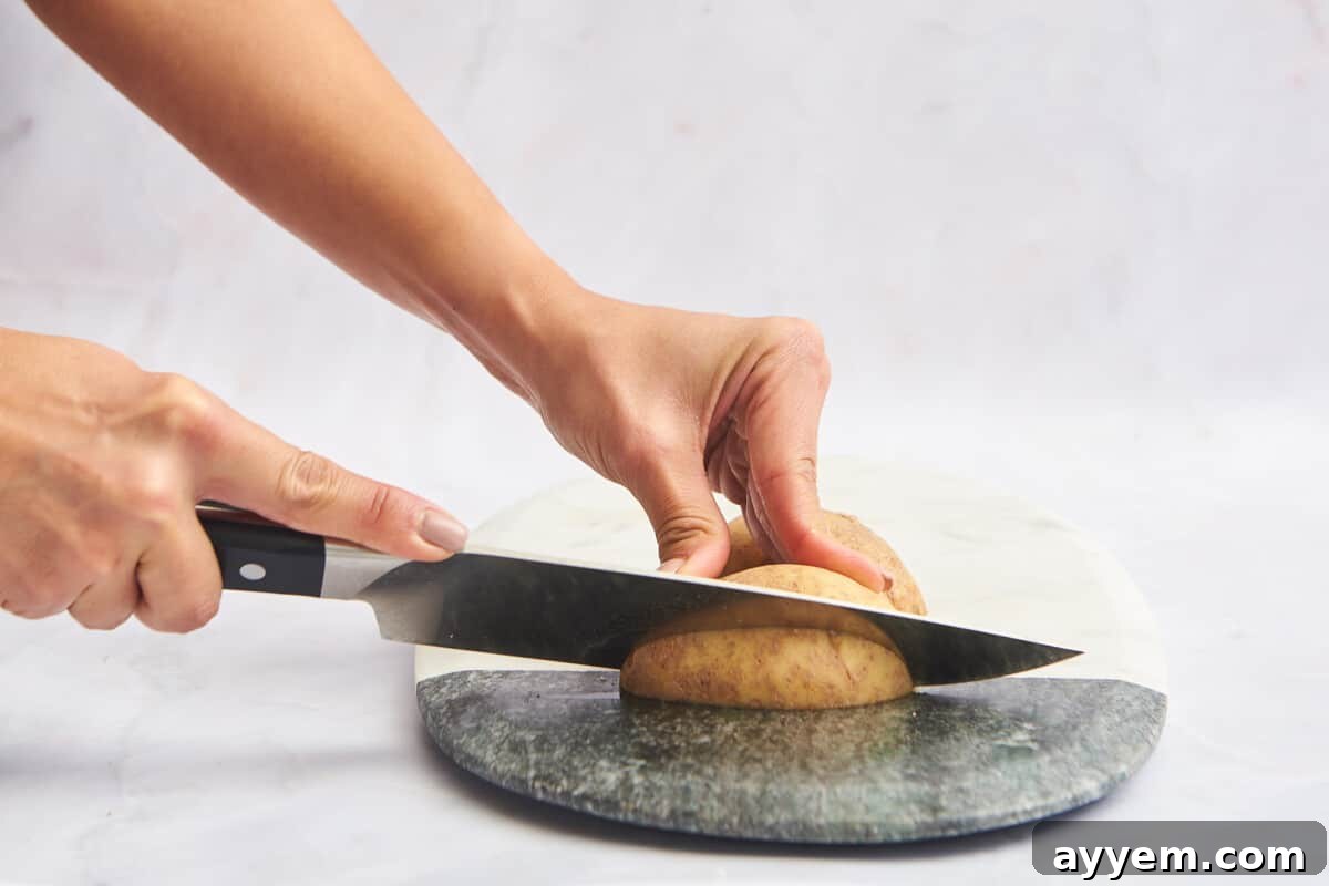 Potato halves being sliced again lengthwise into quarters.