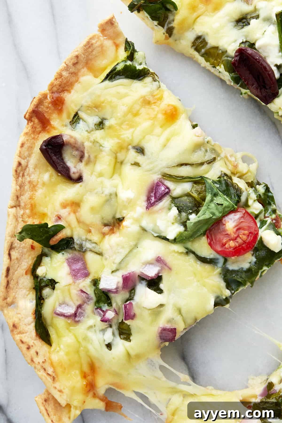 Egg and tortilla bake with tomatoes, red onion, olives, spinach, feta, and mozzarella. 