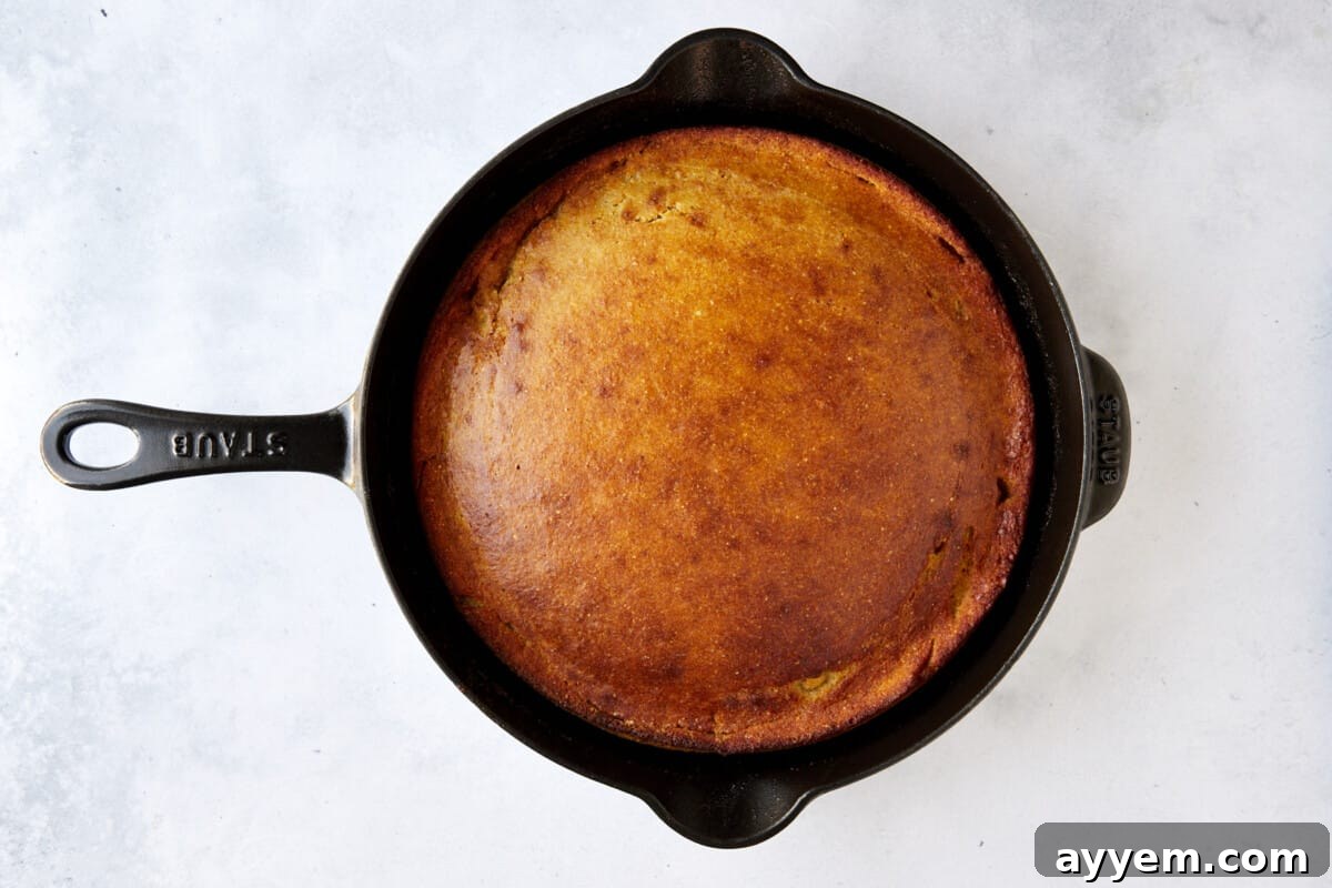 A cast iron skillet full of baked brown butter cornbread. 