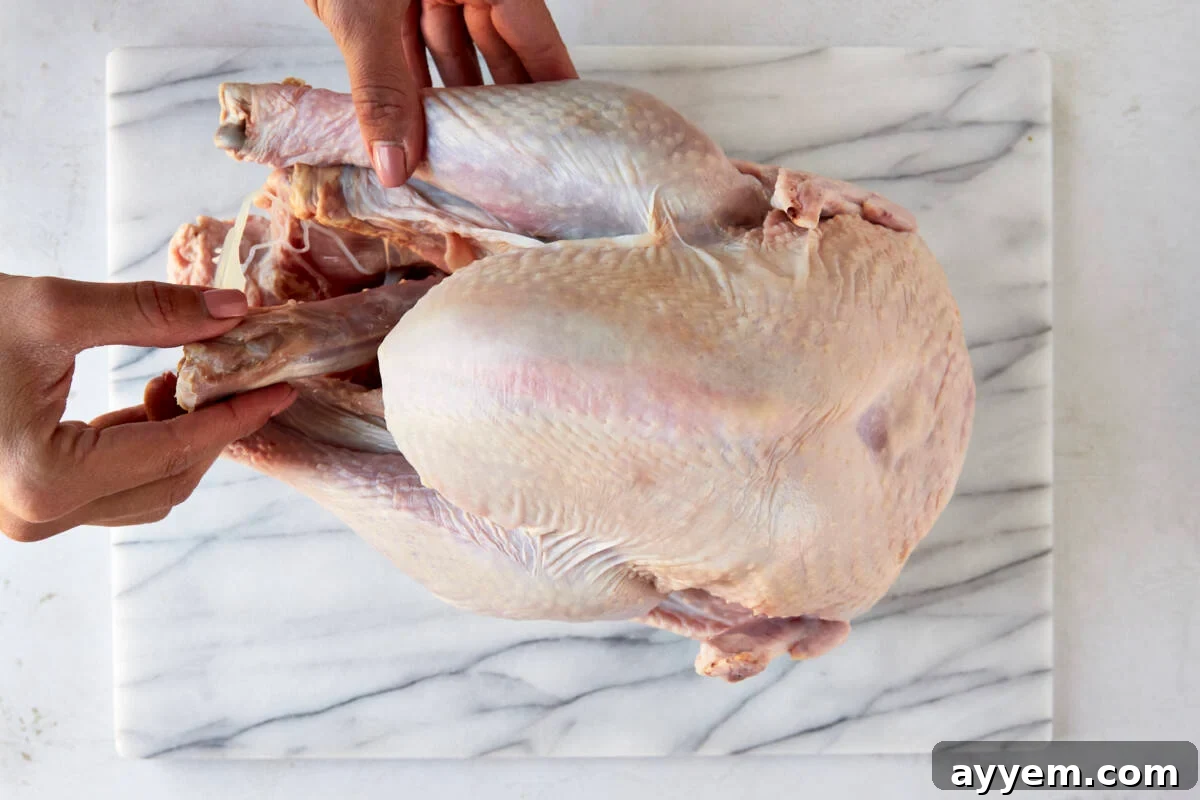 Removing the neck and giblets from a raw turkey, a crucial step for preparation.
