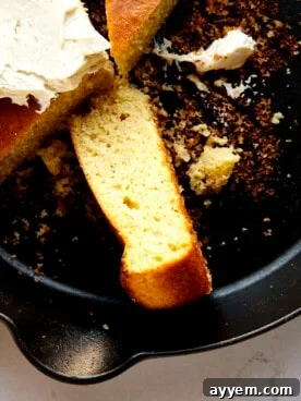 A golden-brown piece of brown butter cornbread, perfectly baked in a cast-iron skillet.