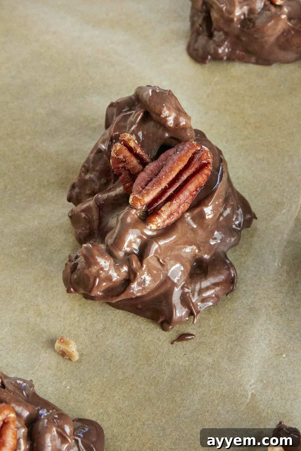 A single delectable caramel pecan cluster, perfectly formed and ready to be enjoyed, resting on a baking sheet.