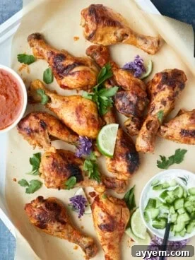 Oven-baked Peri Peri Chicken Drumsticks in a baking dish, golden and glistening.