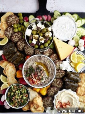 An overhead view of a large, colorful Mediterranean Mezze Platter with hummus, olives, feta, and fresh vegetables.