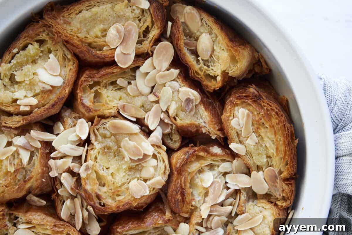 A golden-brown baking dish filled with almond croissant French toast, fresh out of the oven.