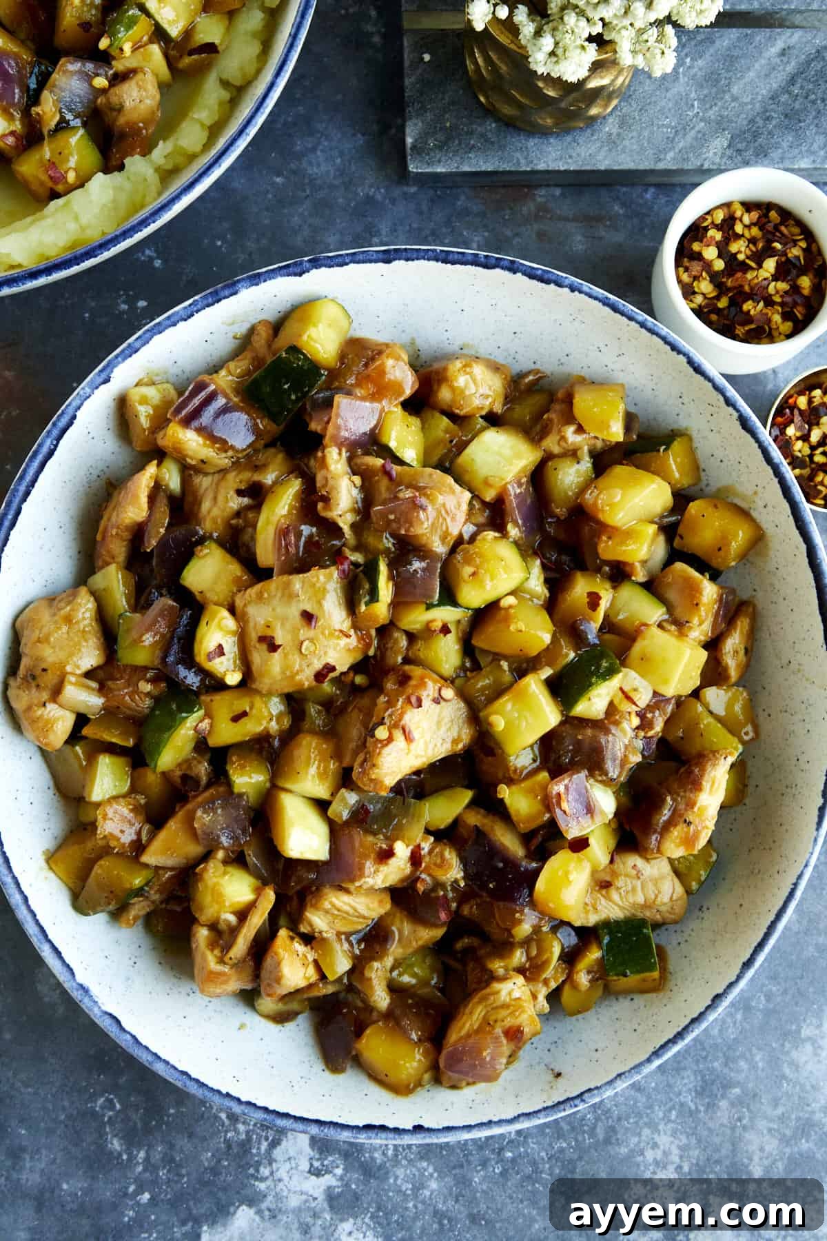 A bowl of chicken and zucchini stir fry.