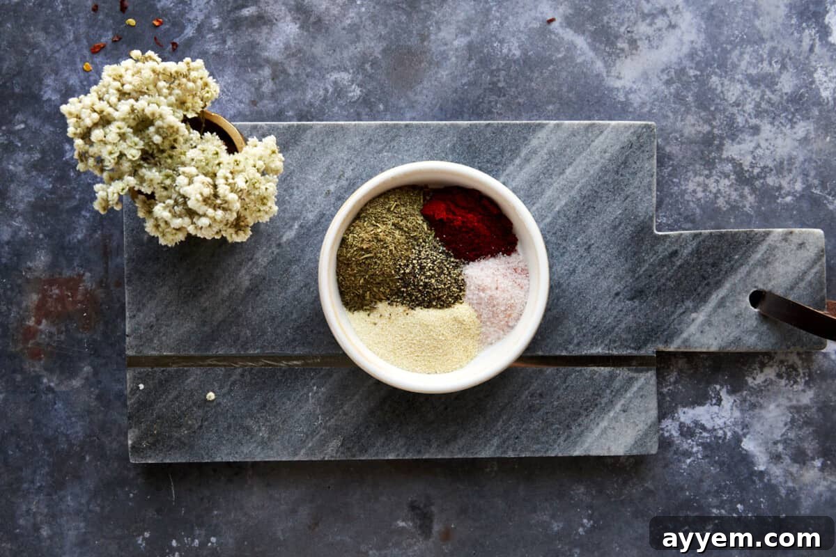 A small bowl of Italian seasoning, garlic powder, smoked paprika, salt, and black pepper.