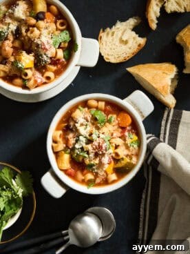 A generous bowl of homemade Minestrone Soup, brimming with colorful vegetables, pasta, and beans, ready to be served.