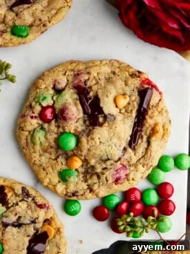 A festive Christmas Monster Cookie, generously studded with colorful holiday M&M's, peanut butter chips, and chocolate chunks.