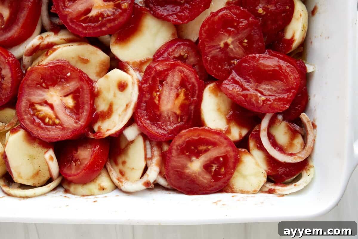 Egyptian Potato Bake 3 A baking dish with potatoes, onions, garlic, and tomatoes.