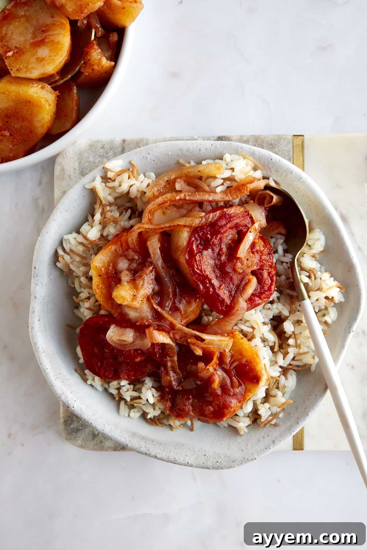A bowl of sanyet el batates over vermicelli rice.