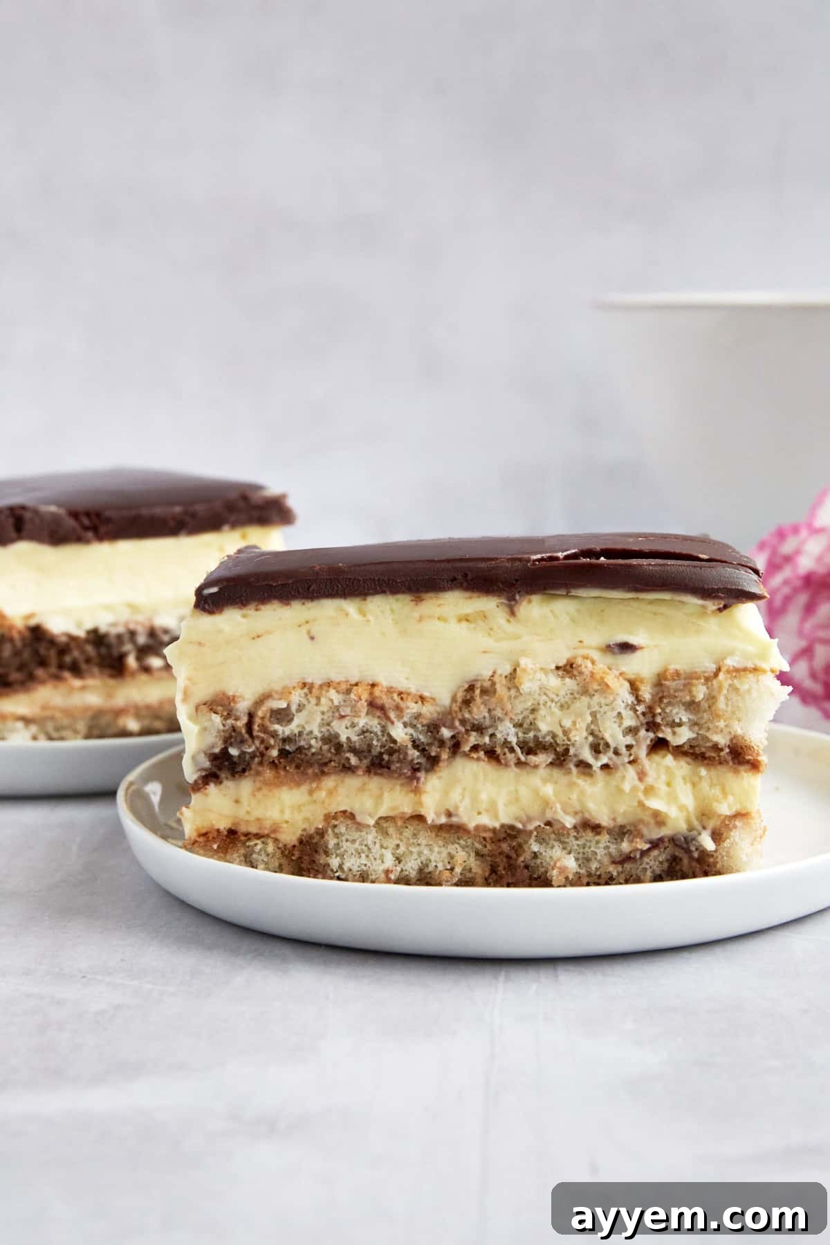 Two plates with slices of tiramisu eclair cake. 