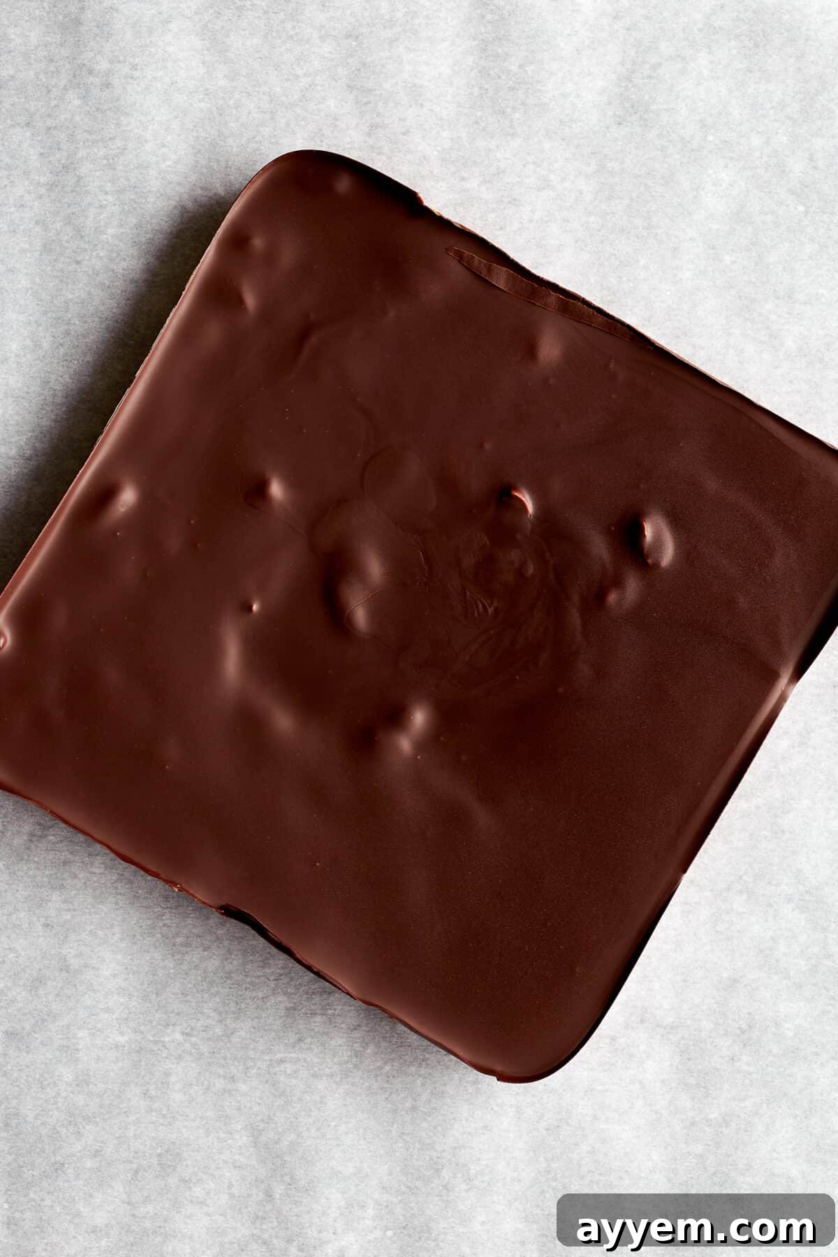 A slab of chocolate peanut butter bars ready to be sliced. 