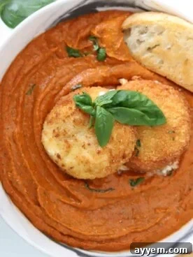 Overhead image of a bowl of crispy fried burrata with vibrant romesco sauce, accompanied by crusty bread.