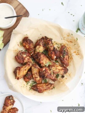 A bowl overflowing with perfectly crispy air fryer chicken wings, coated in a savory dry rub.