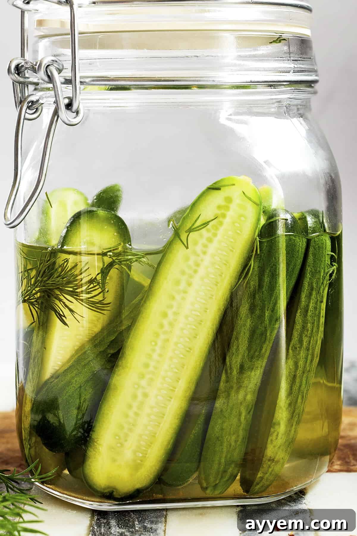 Zesty Marinated Cucumbers 3 A sealed glass jar filled with vibrant green marinated cucumbers, showcasing the clear, herbaceous brine and the neatly arranged cucumber slices, ready for refrigeration and flavor infusion.
