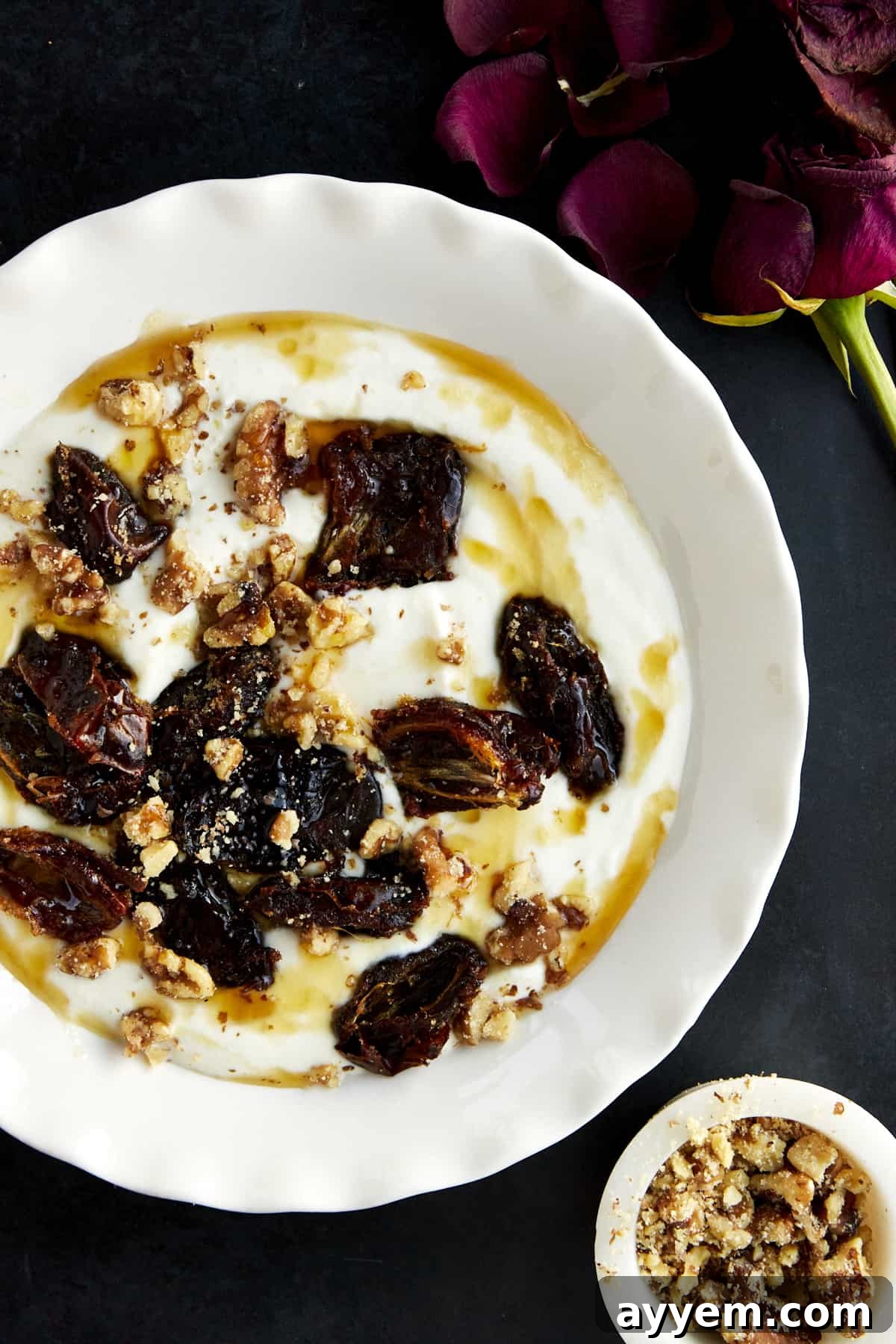 A bowl of honey whipped ricotta topped with roasted dates and walnuts. 