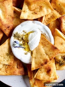 A close-up of perfectly crispy, golden homemade pita chips arranged neatly, showing their delicious texture and inviting seasoning, ideal for snacking.