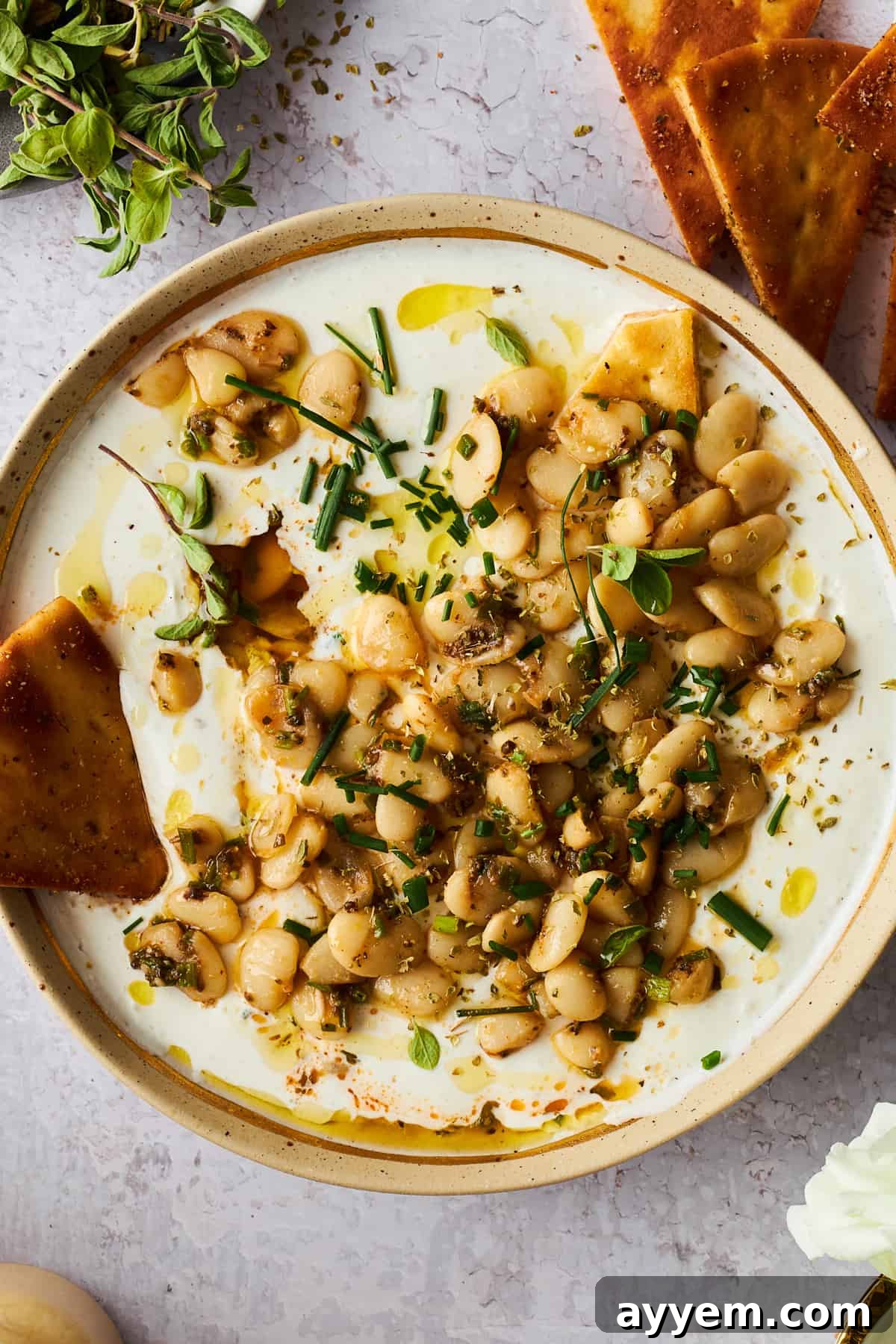 Marinated butter beans with whipped cottage cheese and a pita chip on the side. This vibrant, healthy dip is perfect for entertaining or a quick, satisfying snack.