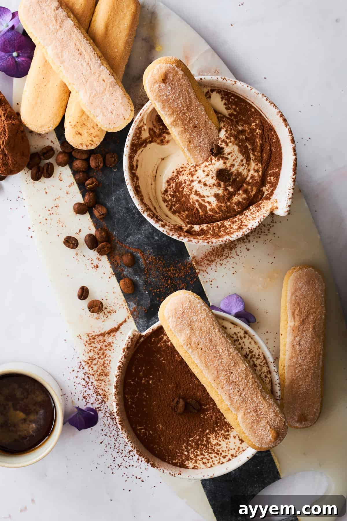 Several small bowls of Tiramisu Dip arranged with ladyfinger cookies, ready for a dessert party.