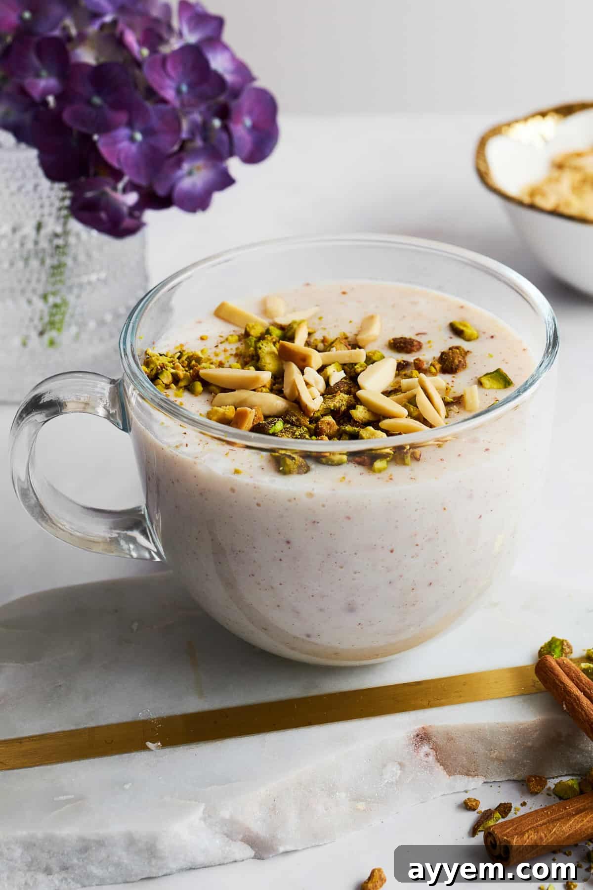 A close-up of a mug of Sahlab, richly topped with crushed nuts and a dusting of cinnamon, inviting a warm sip.