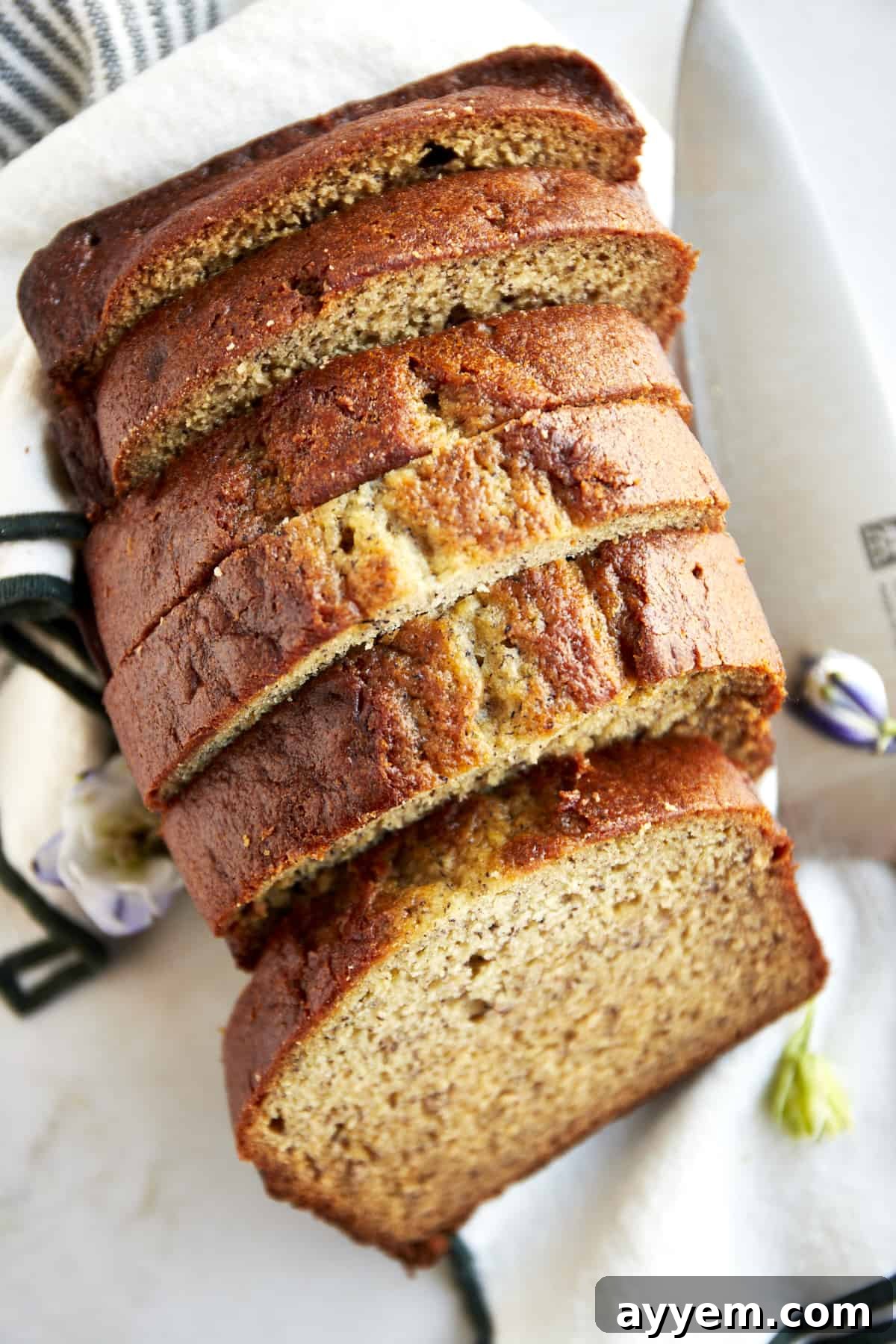 A loaf of blender banana bread sliced into pieces, showcasing its moist texture and rich golden-brown crust.