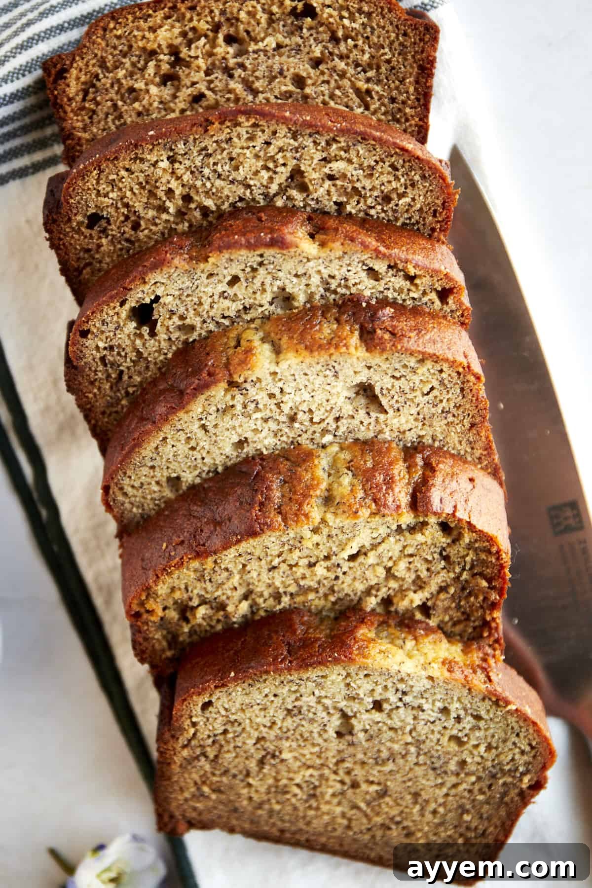 Perfectly baked slices of blender banana bread on a wooden cutting board, ready to be enjoyed.