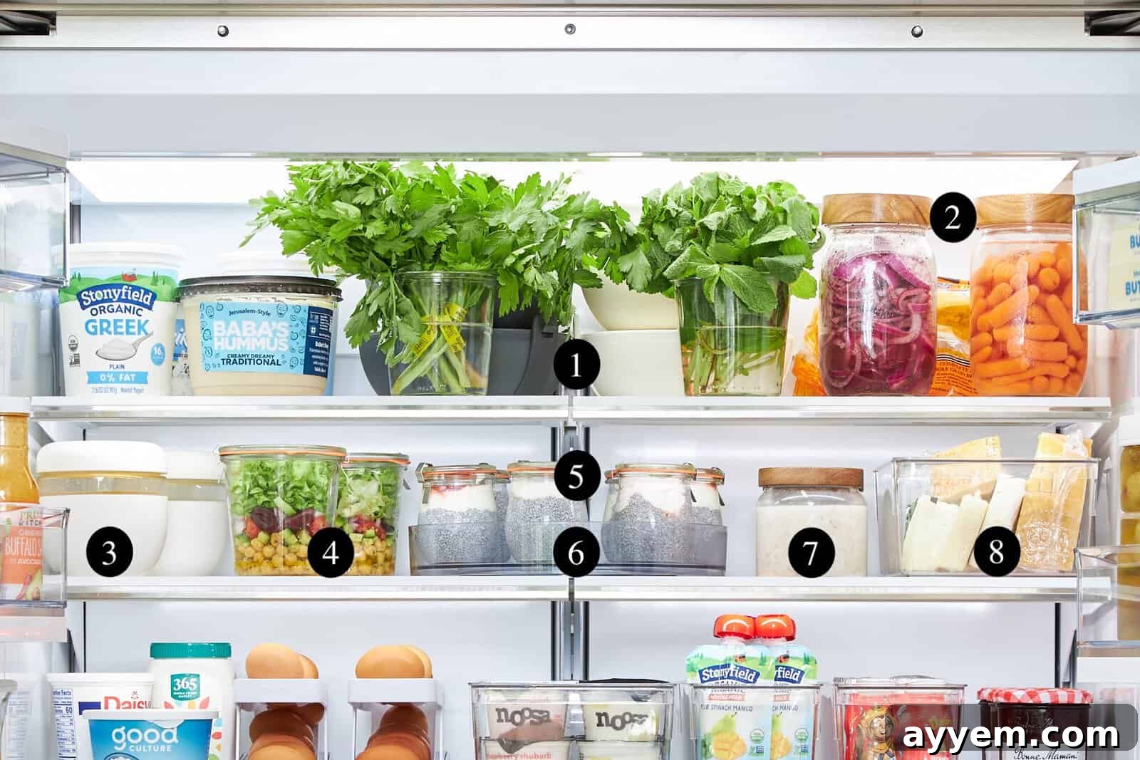 Various ceramic and glass storage containers with bamboo lids neatly arranged in a refrigerator.