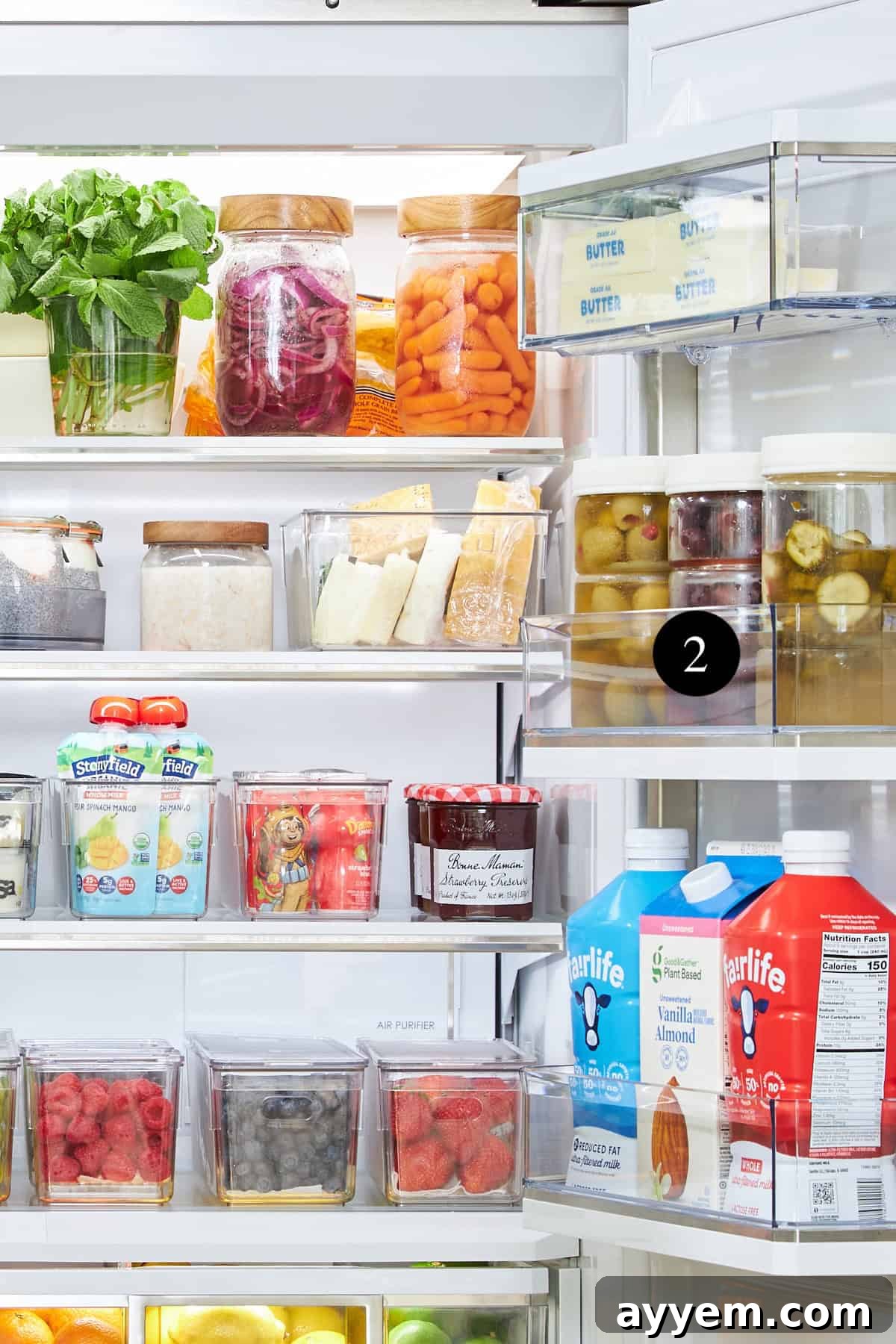 Various items, including sauces and containers, neatly organized on a Lazy Susan in a refrigerator.