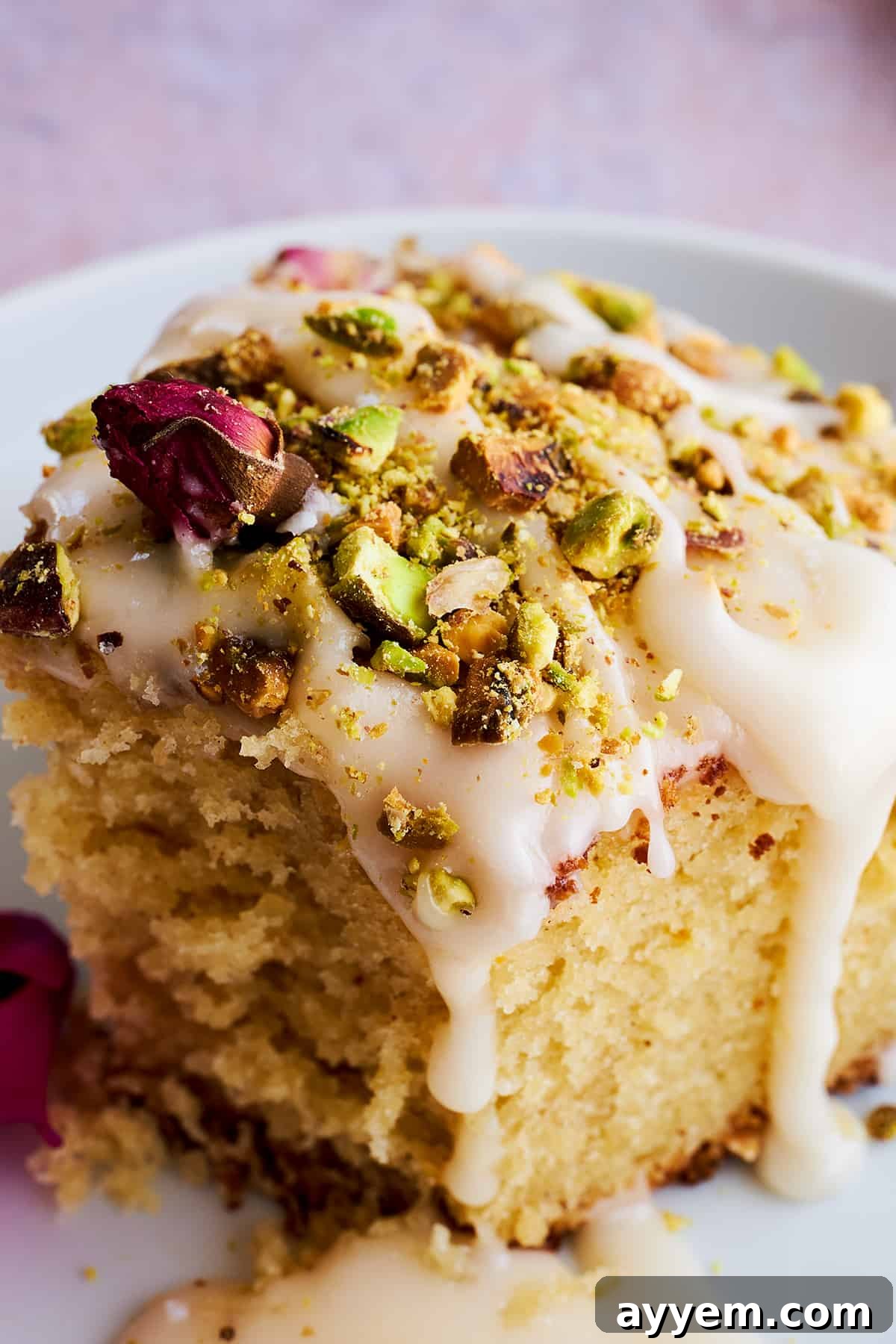 A rustic cutting board holds a large, whole Persian love cake, waiting to be sliced and enjoyed.