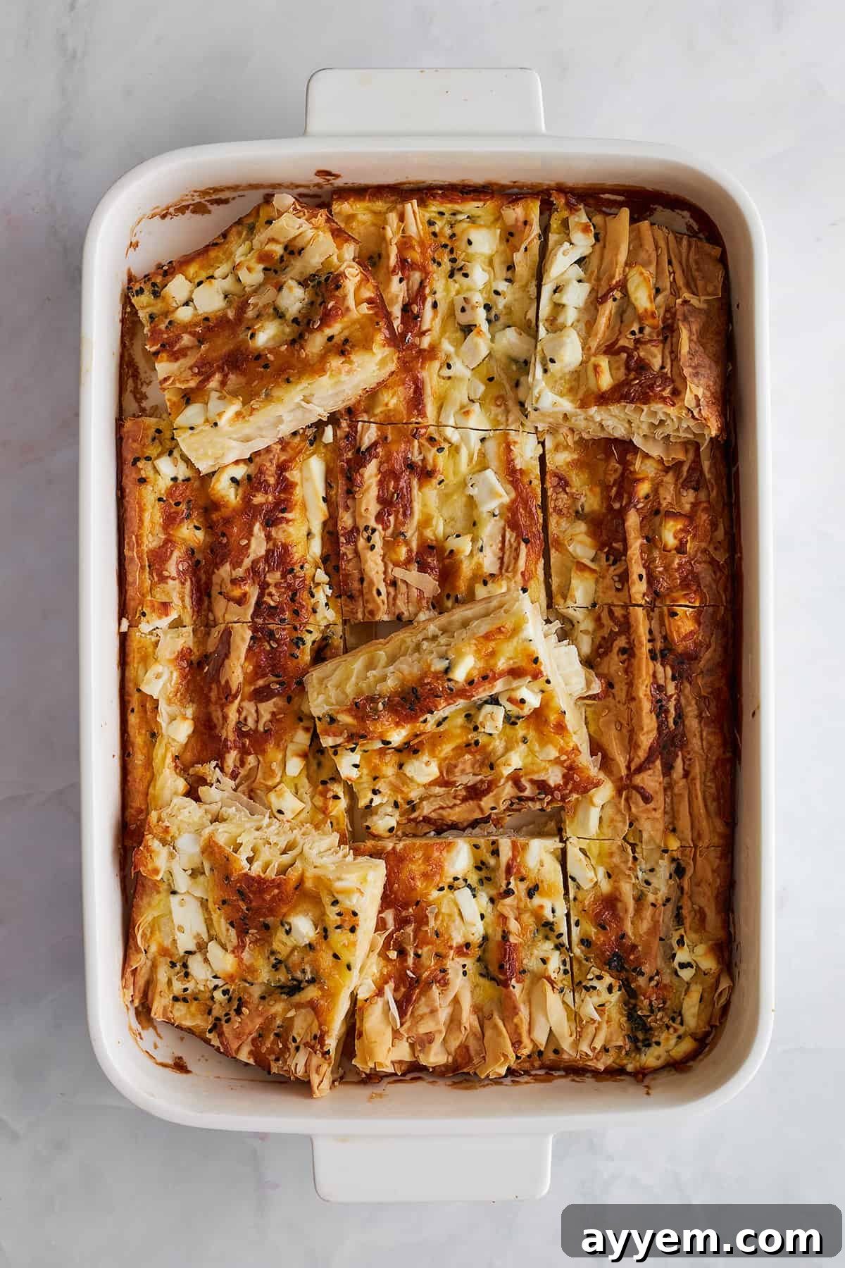 Crinkle Feta Cheese Phyllo cut into square portions on a serving board.