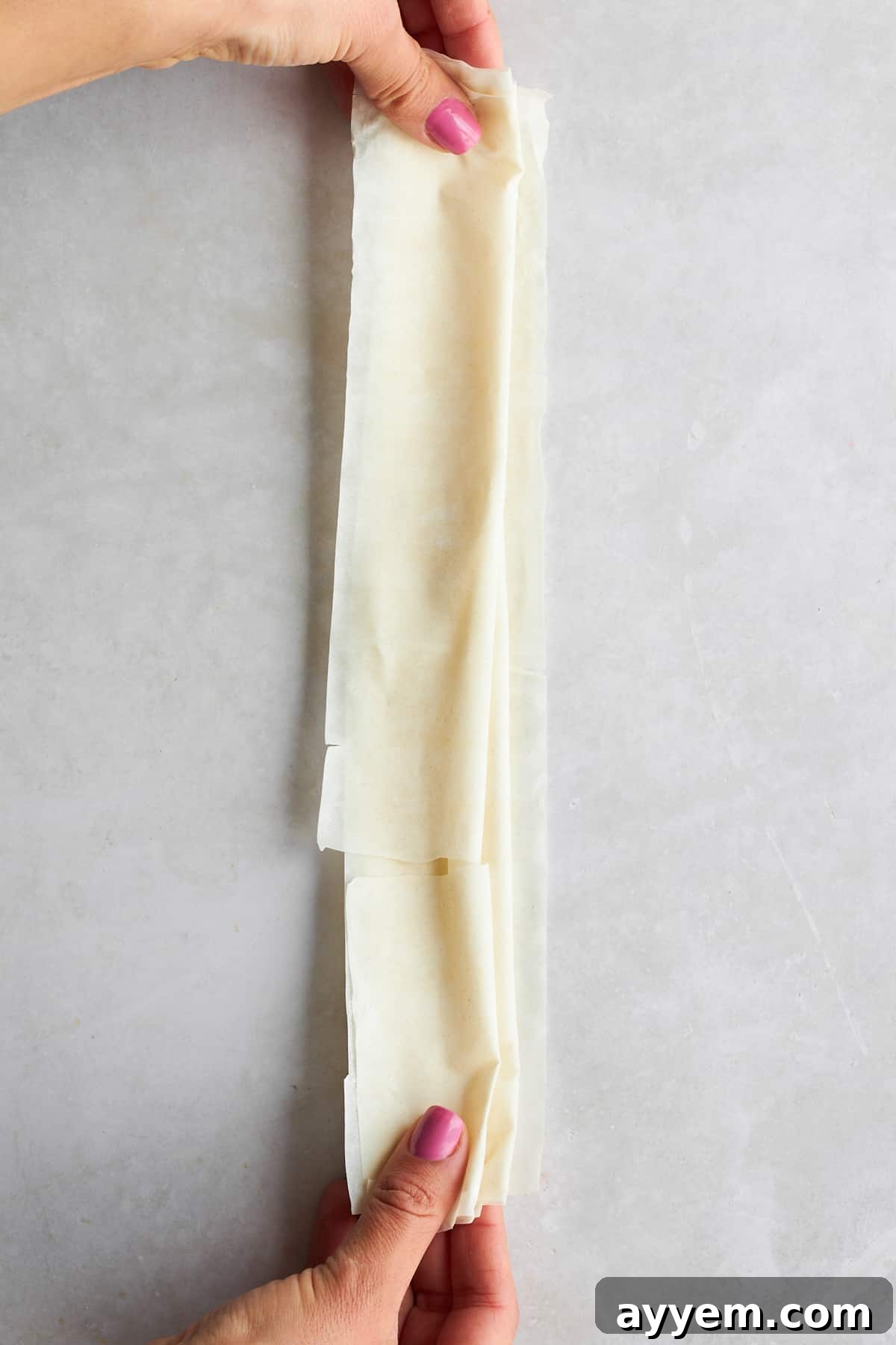 Close-up of scrunched phyllo dough being placed into a baking dish.
