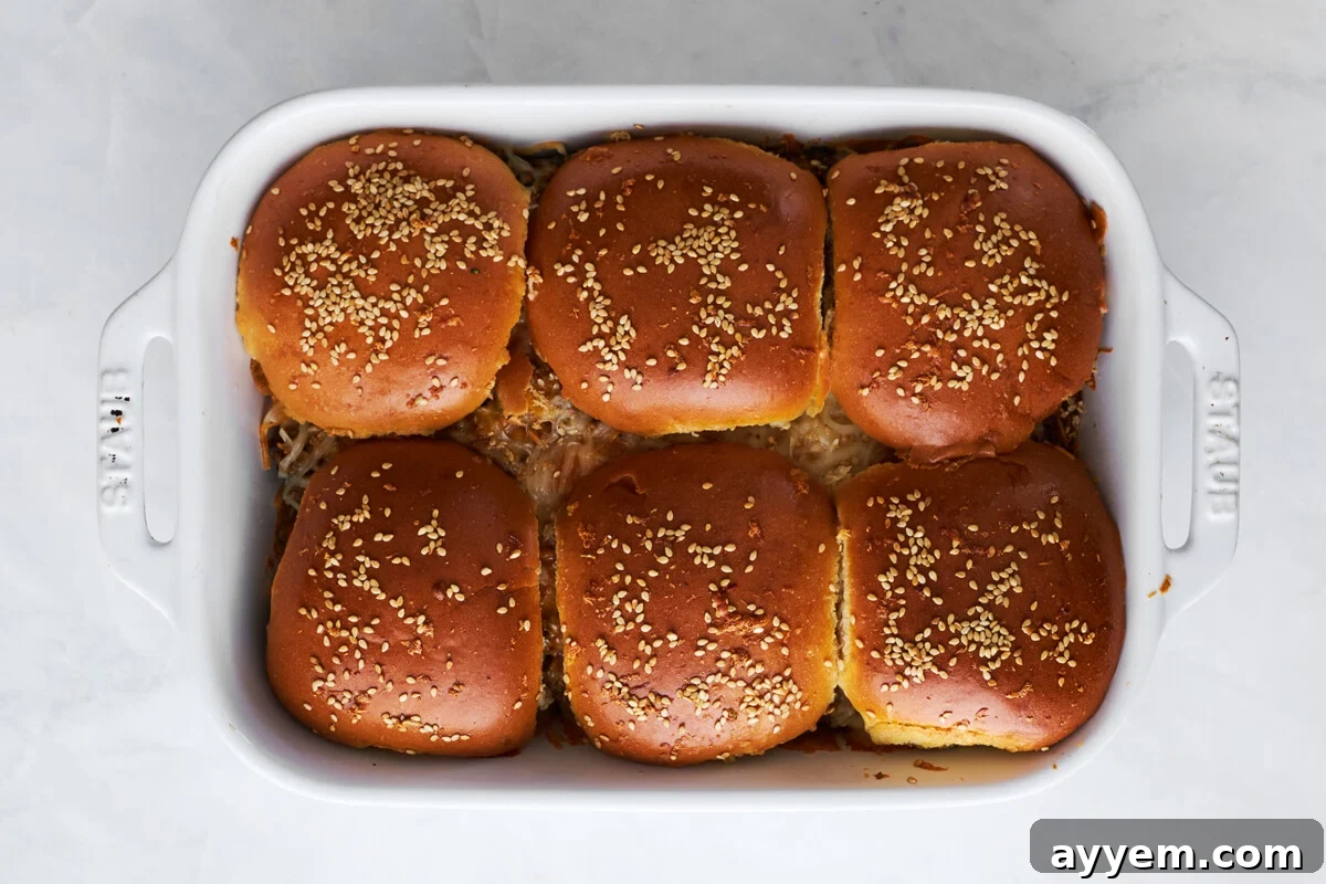 Baked cheesy ground beef sliders in a baking dish.