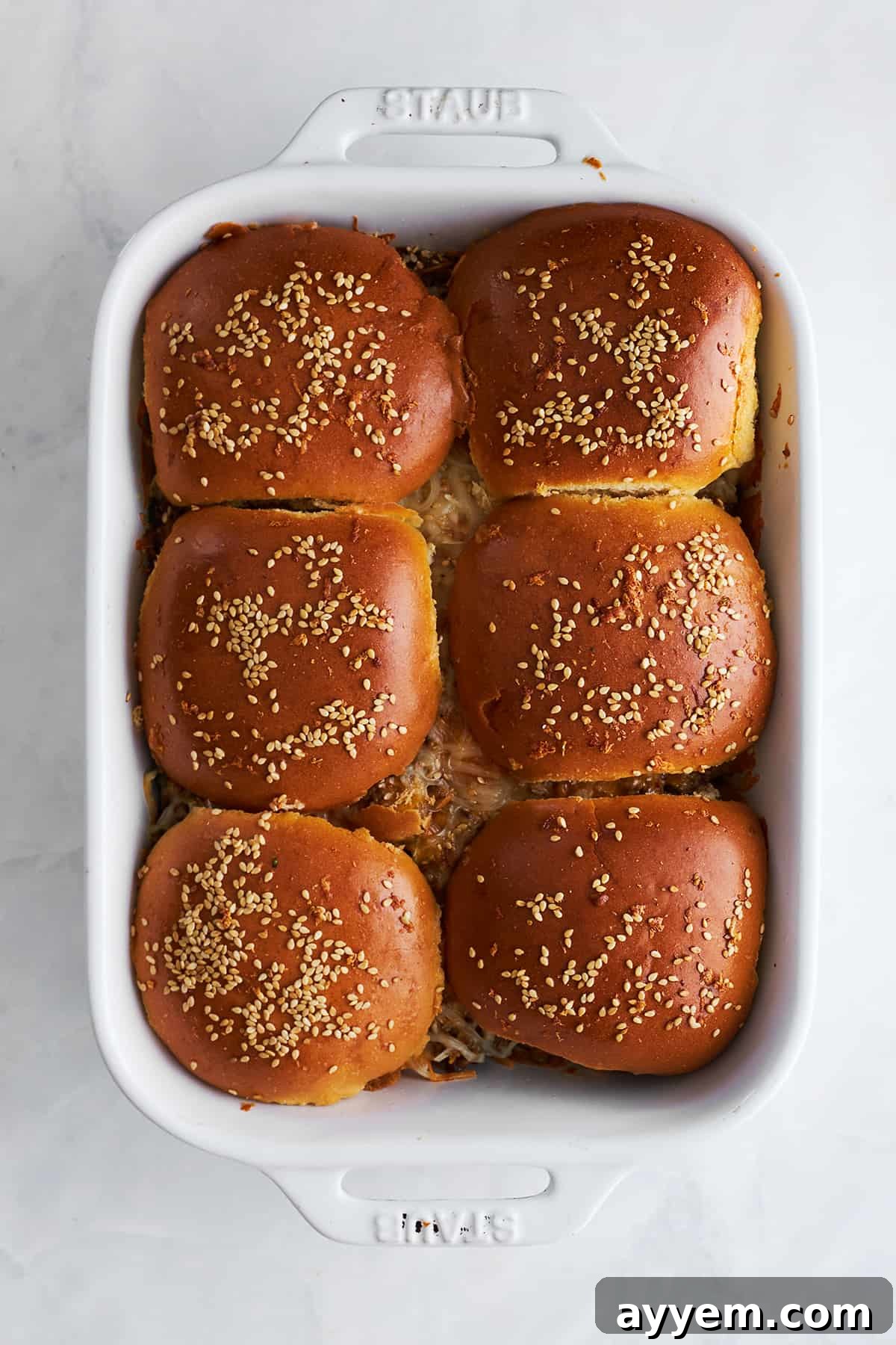 Baked cheeseburger sliders in a baking dish. 