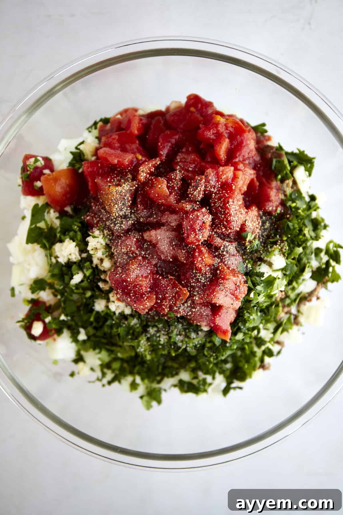 Individual ingredients for the stuffed pepper filling, including cooked rice, diced tomatoes, and fresh herbs, in separate small bowls.