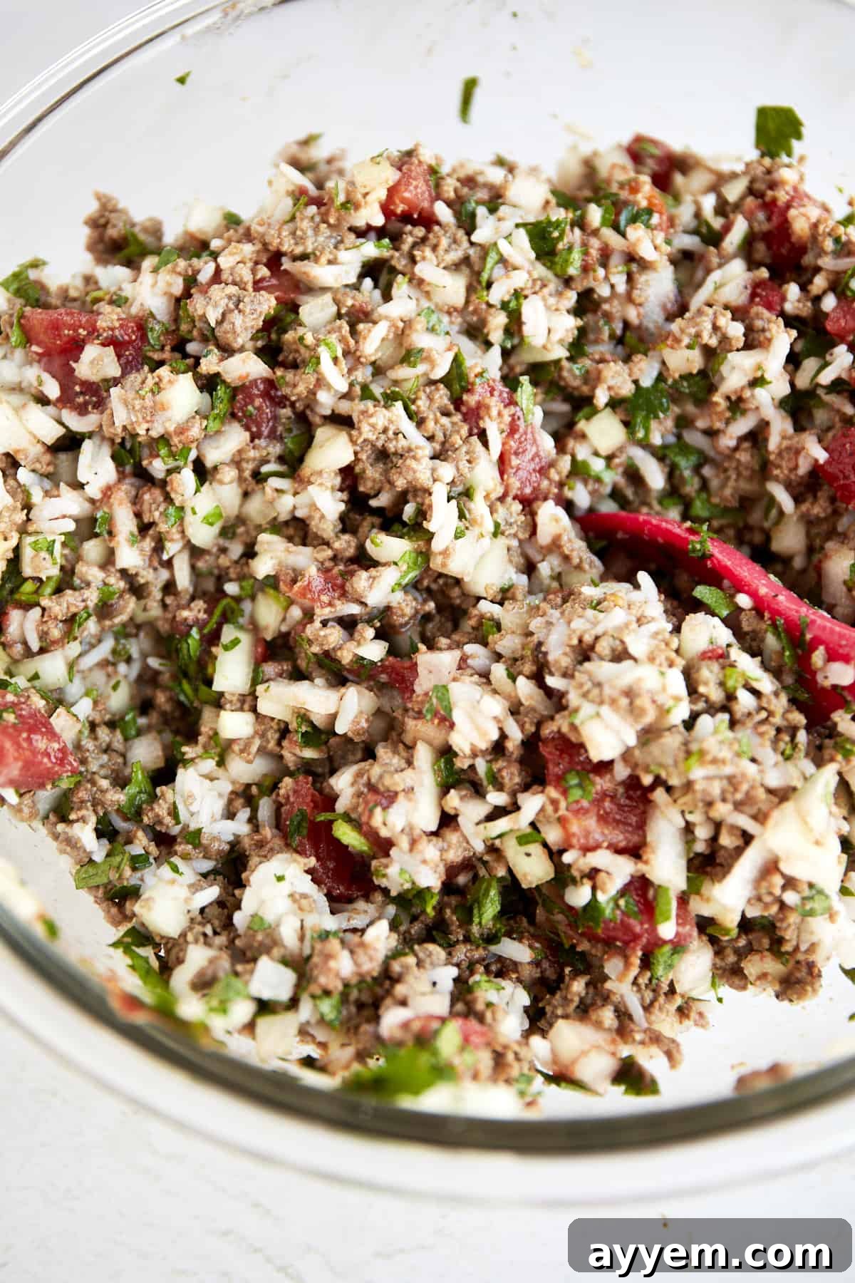 The mixed Mediterranean stuffed pepper filling, a colorful blend of ground beef, rice, tomatoes, and herbs, in a large mixing bowl.
