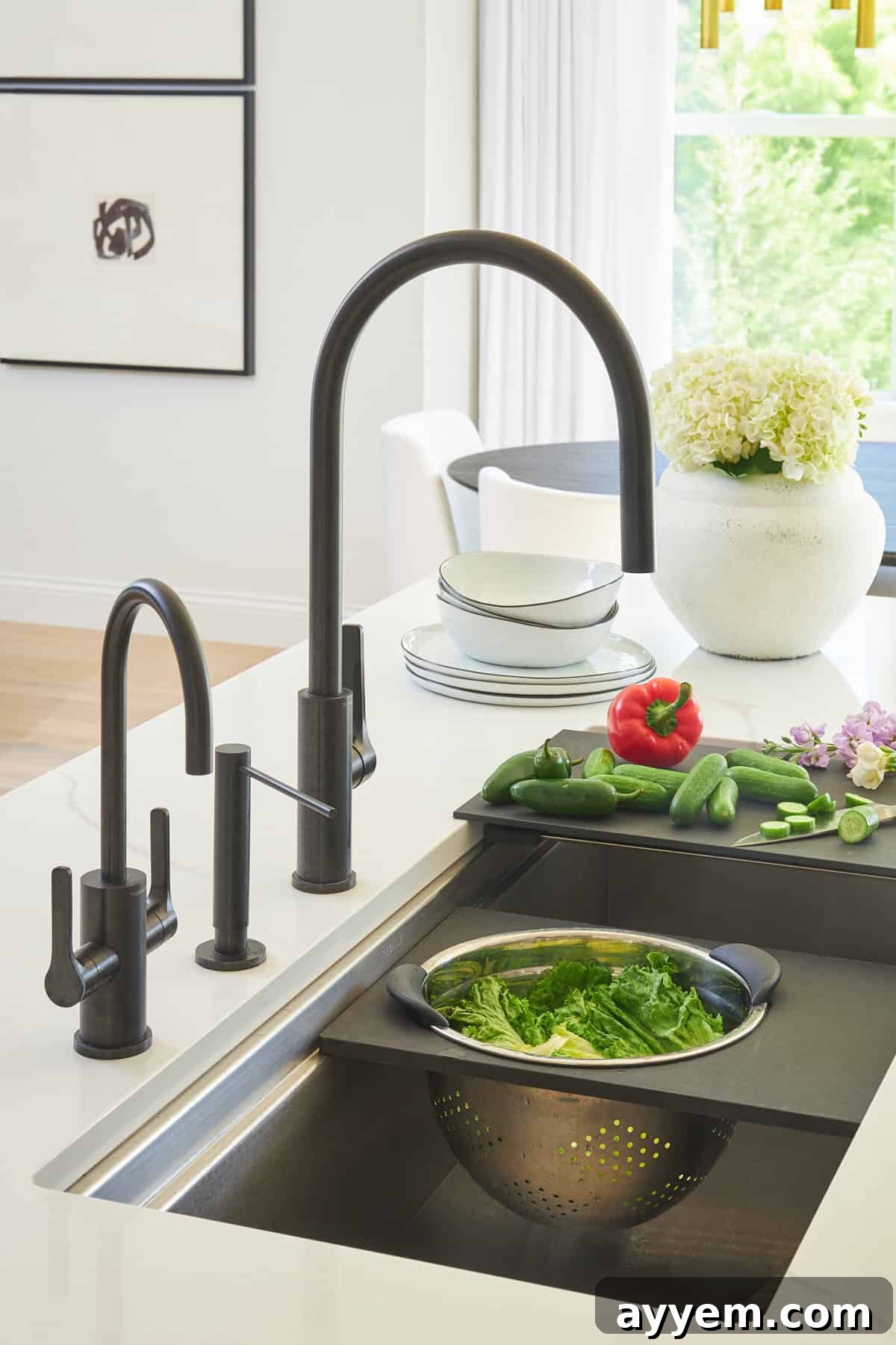 Unlock Your Kitchen's Potential: Workstation Design 2 A kitchen sink with attachments for a cutting board with veggies and a colander.