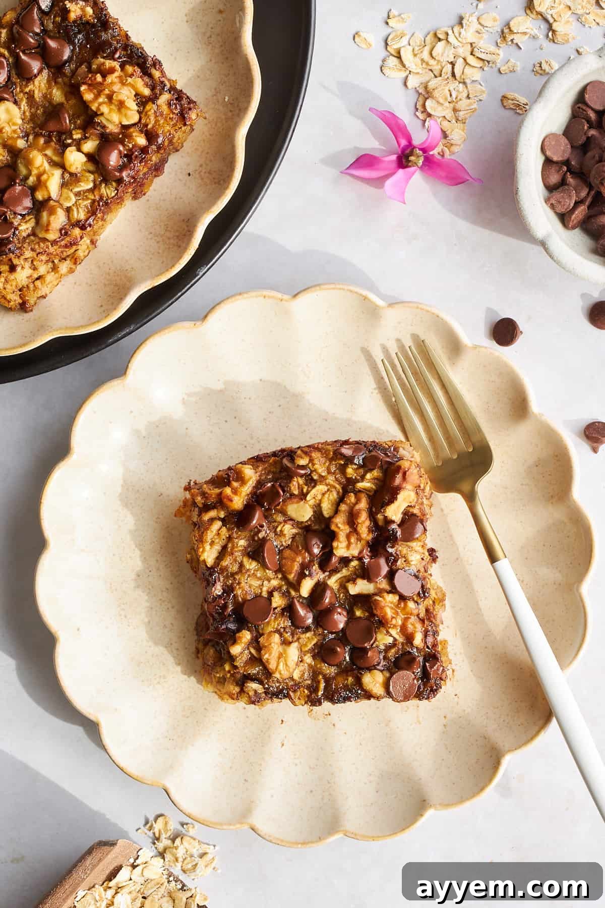 A slice of banana date baked oatmeal on a plate with a fork, showing its delicious texture.