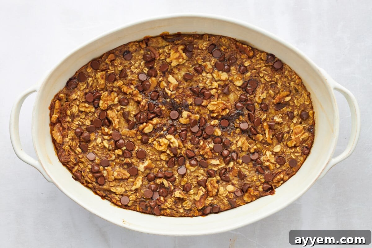 Baked banana date oatmeal in an oval baking dish, golden and bubbly.