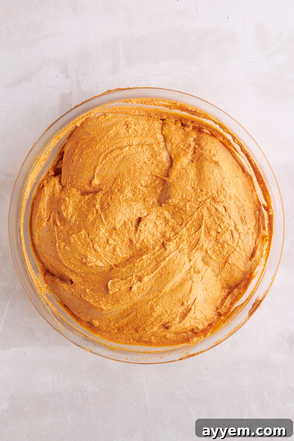 Chicken breasts coated in shawarma marinade in a bowl.