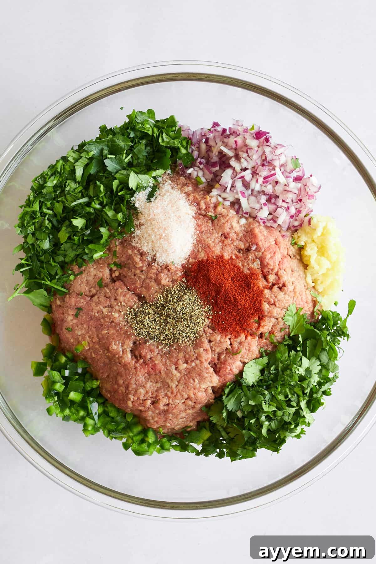Fresh ingredients laid out for making beef kofta, including herbs and spices.