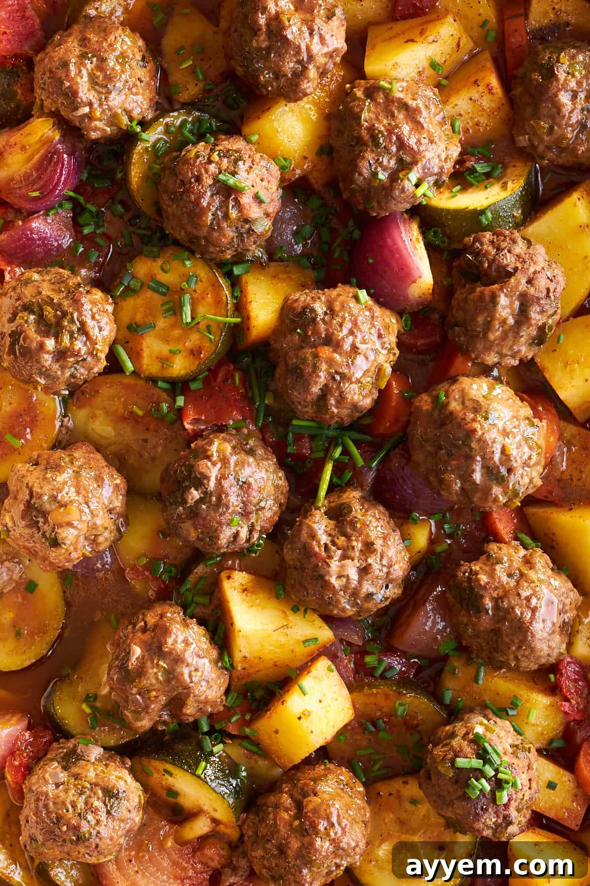 Close-up of a perfectly baked Beef Kofta Bake, showcasing tender meatballs and vibrant roasted vegetables.